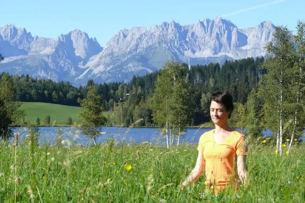 Woman meditation at lake in the Alps