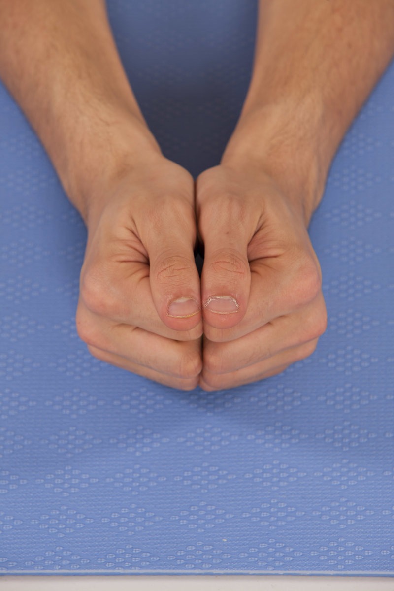 Two fists together in Locust Pose