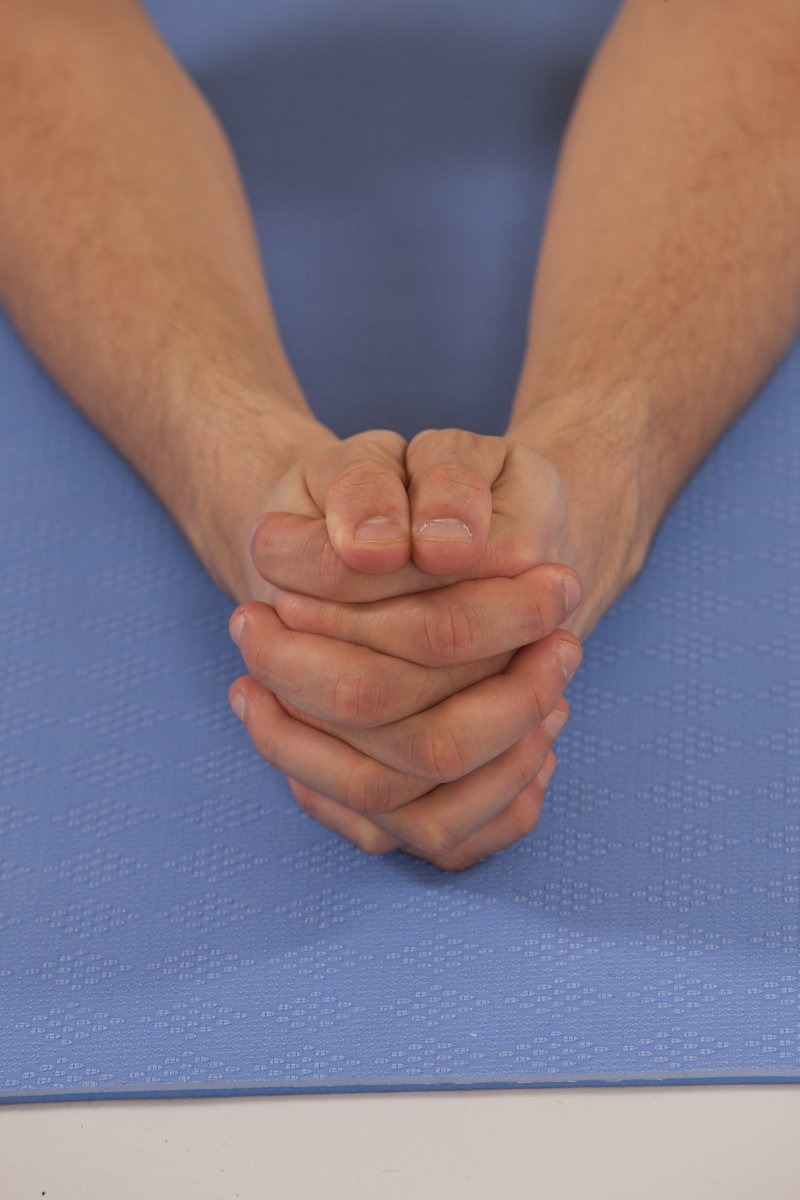 Fingers interlocked for the Locust Pose